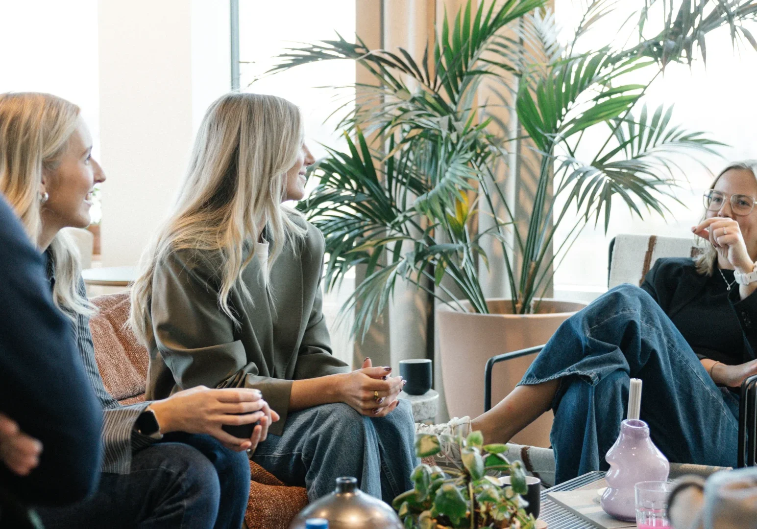 I ett ljust rum med stora fönster och krukväxter sitter fyra personer och småpratar och ler medan de håller i drinkar. Den avslappnade, vänliga atmosfären speglar den kreativa andan hos Reklam & Co byrå i Motala.